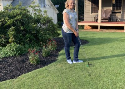 Woman standing in front of a luxuriant, finely manicured grassy oasis