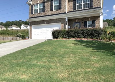 A traditional house with a grassy lawn in front of it.