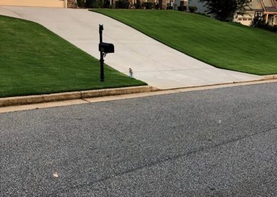 The entrance to a parking lot with beautiful lawns on both sides.