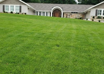 A huge patio in front of a yellow brick house.