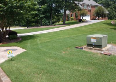 An All Turf sign next to the garage entrance of a beautiful home.